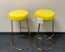 A pair of contemporary bar stools on metal legs upholstered in mustard fabric