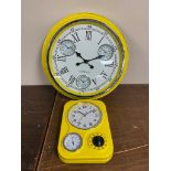 Two yellow enamel wall clocks