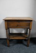 An early 20th century oak fall fronted side table on bobbin legs