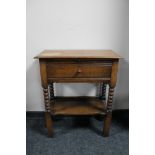 An early 20th century oak fall fronted side table on bobbin legs