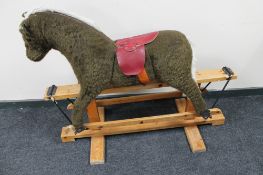 A soft toy rocking horse on pine stand