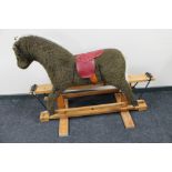 A soft toy rocking horse on pine stand