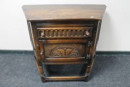 A carved oak low cabinet fitted with a drawer,