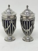 A pair of Edwardian Neo-Classical silver salts with blue glass liners, London 1908, height 10cm.