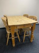 A pine farmhouse kitchen table fitted with a drawer together with four pine dining chairs