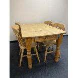 A pine farmhouse kitchen table fitted with a drawer together with four pine dining chairs