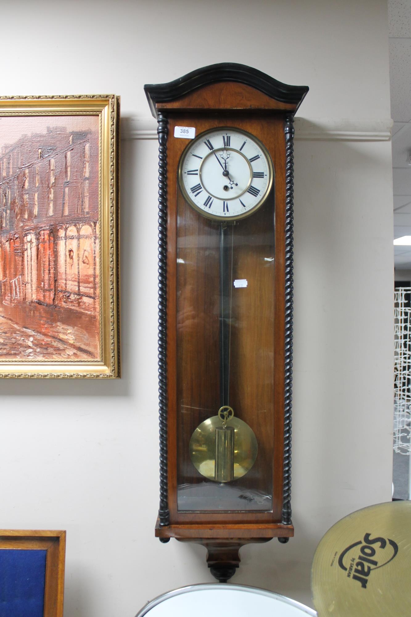 An early 20th century mahogany cased wall clock with brass and enamelled dial, pendulum,