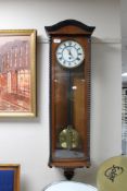 An early 20th century mahogany cased wall clock with brass and enamelled dial, pendulum,