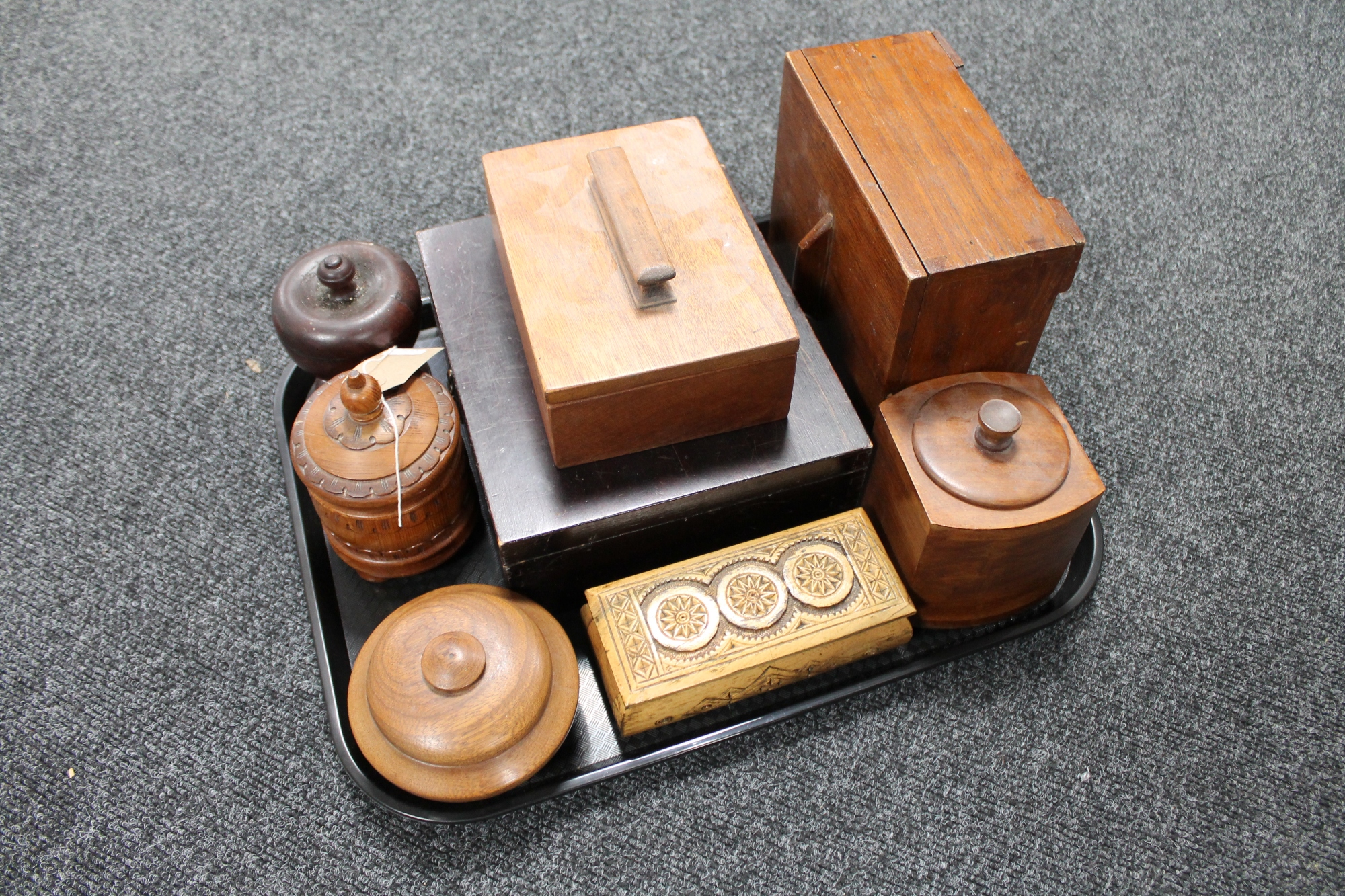 A tray of treen pieces, wooden tobacco jars,