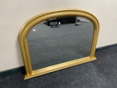 A gilt framed bevelled arch topped overmantel mirror