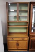 A mid century teak G-plan bookcase fitted with cupboards and drawers