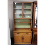 A mid century teak G-plan bookcase fitted with cupboards and drawers