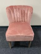 A contemporary bedroom chair in pink fabric