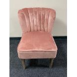 A contemporary bedroom chair in pink fabric