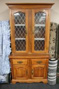 A contemporary oak double glazed cabinet fitted with drawers and cupboards