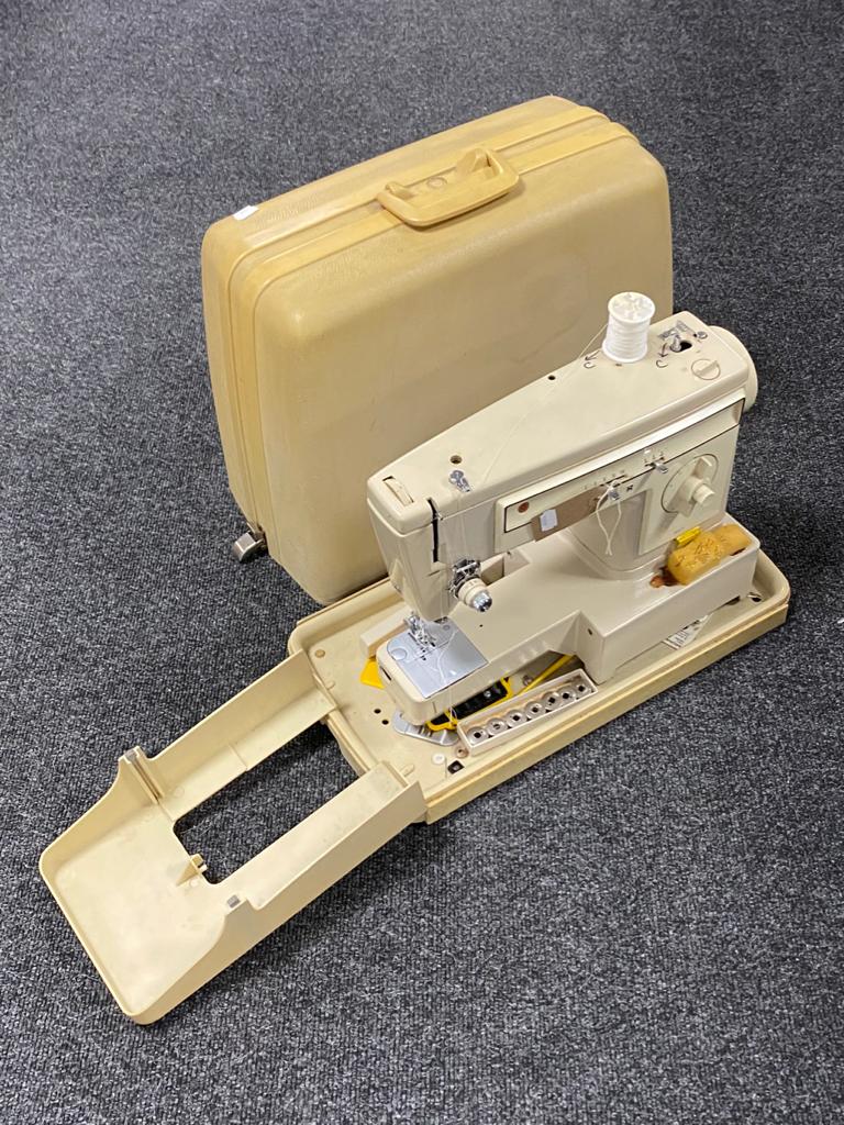 A cased Singer sewing machine (no pedal)
