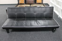 A folding faux leather bed settee