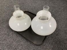 A tray of two vintage glass oil lamp shades and chimneys