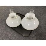 A tray of two vintage glass oil lamp shades and chimneys