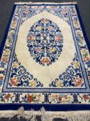 A Chinese floral fringed carpet on blue and cream ground