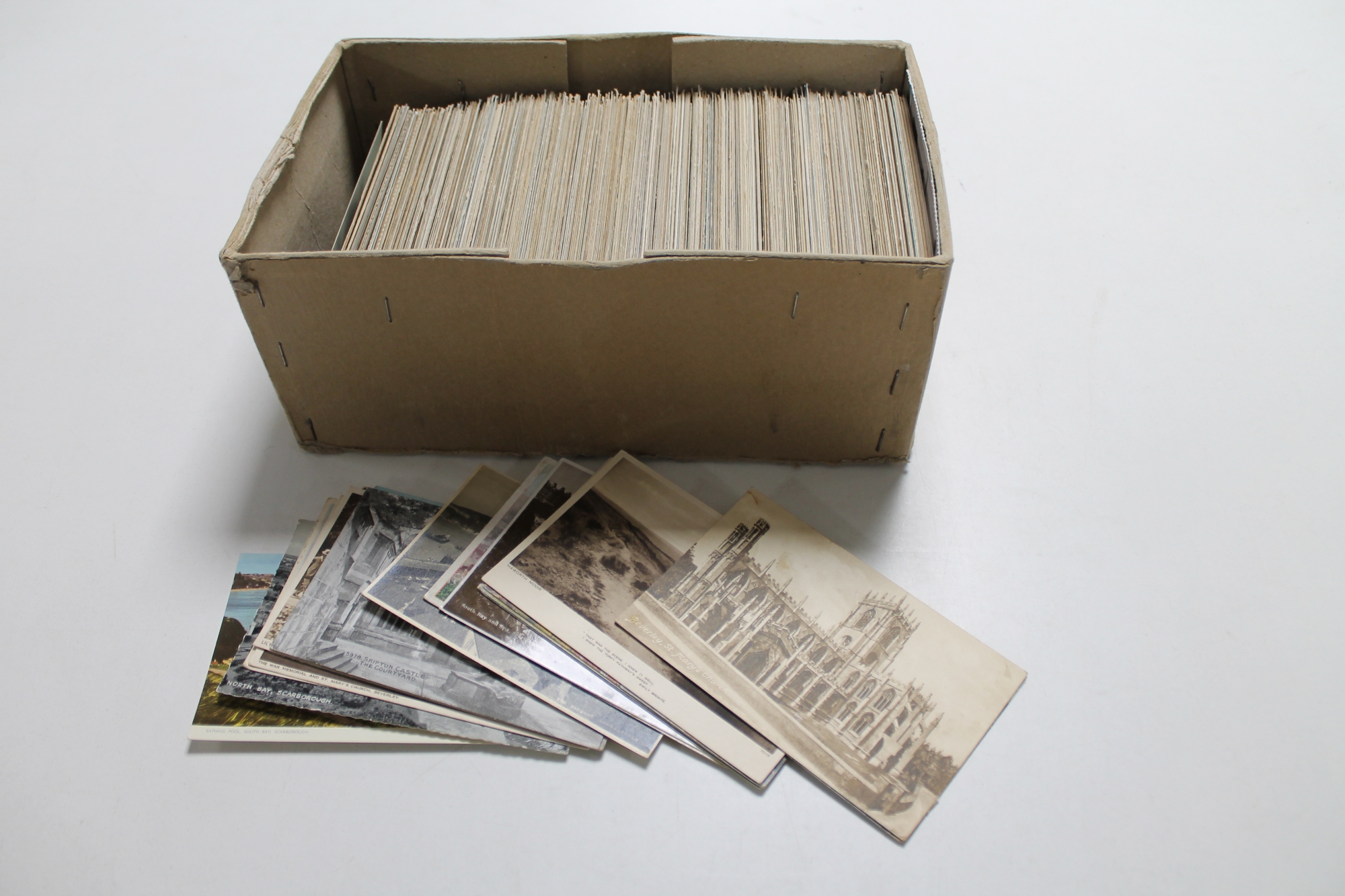 A box of antique and later postcards;