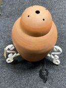 A terracotta floor lamp on iron stand