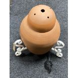 A terracotta floor lamp on iron stand