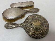 A box of two silver backed dressing table brushes and silver backed mirror