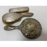 A box of two silver backed dressing table brushes and silver backed mirror