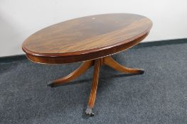 An oval inlaid mahogany pedestal coffee table