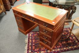 A reproduction yew wood twin pedestal desk, with green leather inset top,