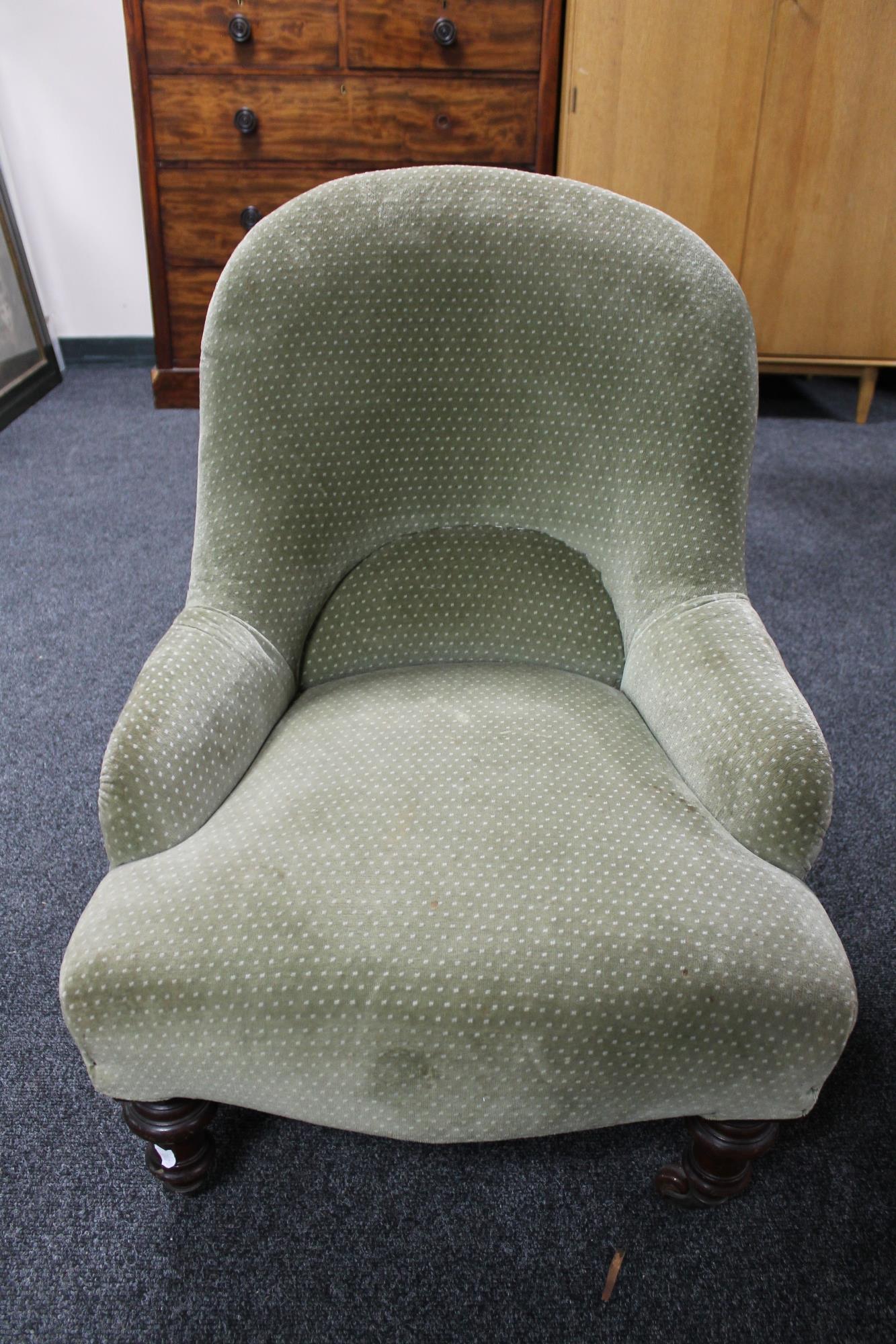 An antique bedroom chair in green fabric