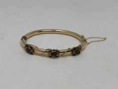 A 14ct gold garnet set hinged bangle CONDITION REPORT: 12g.