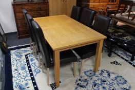 A contemporary oak dining table together with a set of five high back brown leather dining chairs