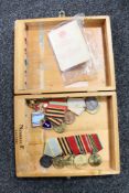 A wooden cigar box containing Russian WWII medals on ribbons and enamelled badges