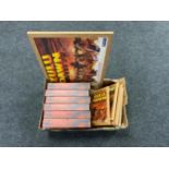 A box of six Zulu Dawn VHS box sets and a further five framed Zulu prints