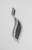 An 18ct white gold leaf pendant, set with 157 black diamonds and 169 white diamonds,
