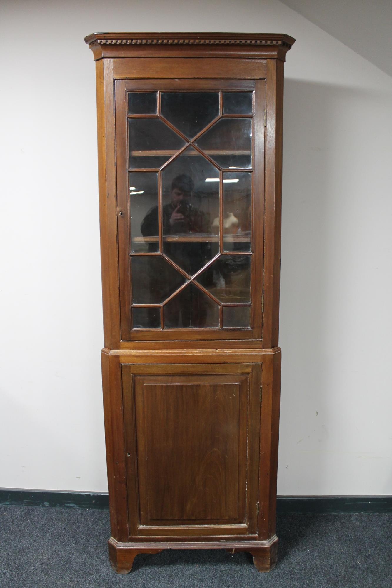 An antique oak astral glazed corner cabinet with panelled door cupboard beneath