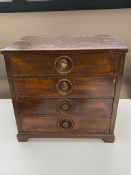 An antique mahogany four drawer miniature desk top chest