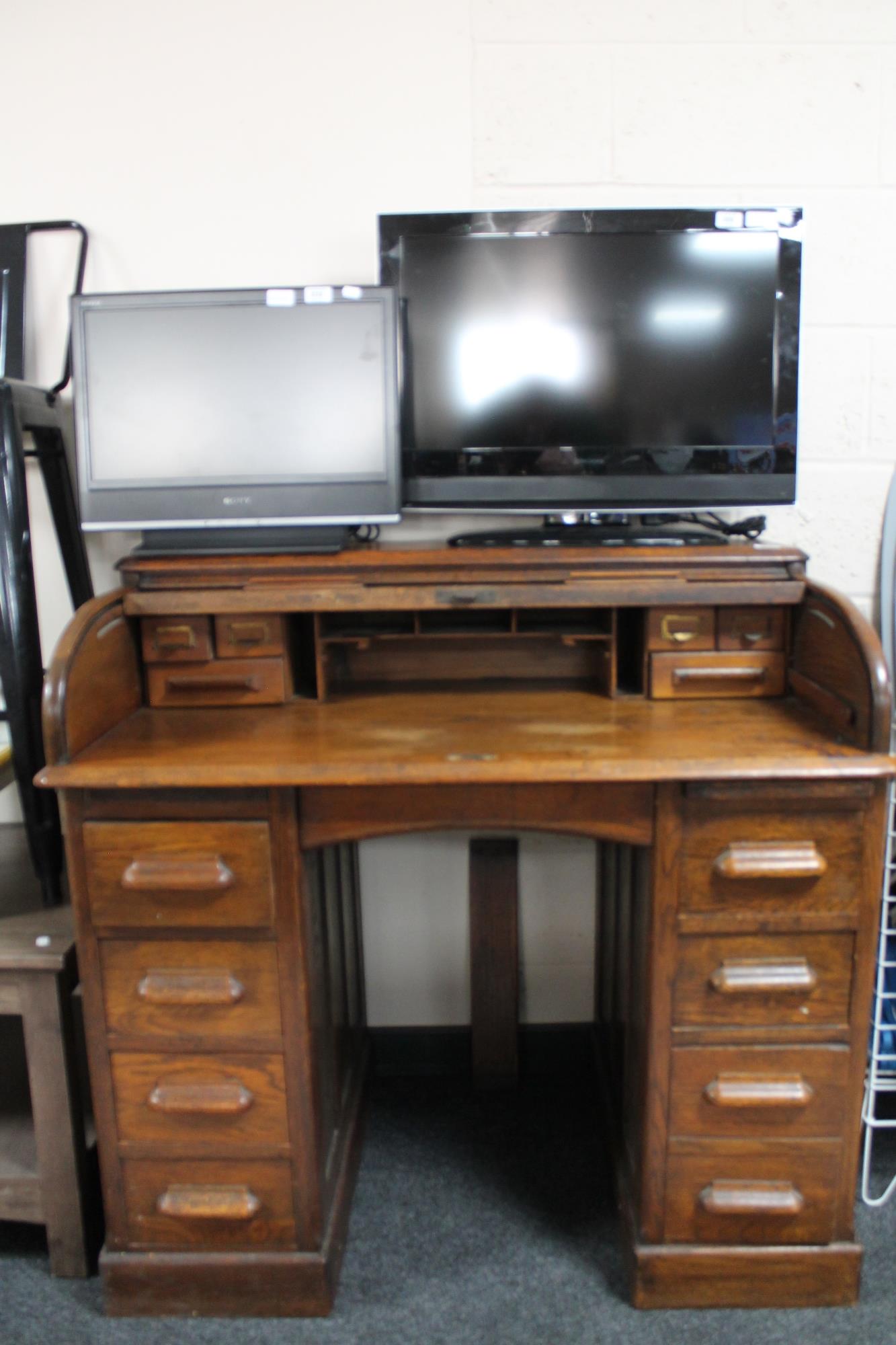 An Edwardian oak roll top desk