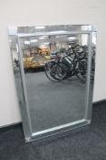 A contemporary all glass framed bevelled edge mirror