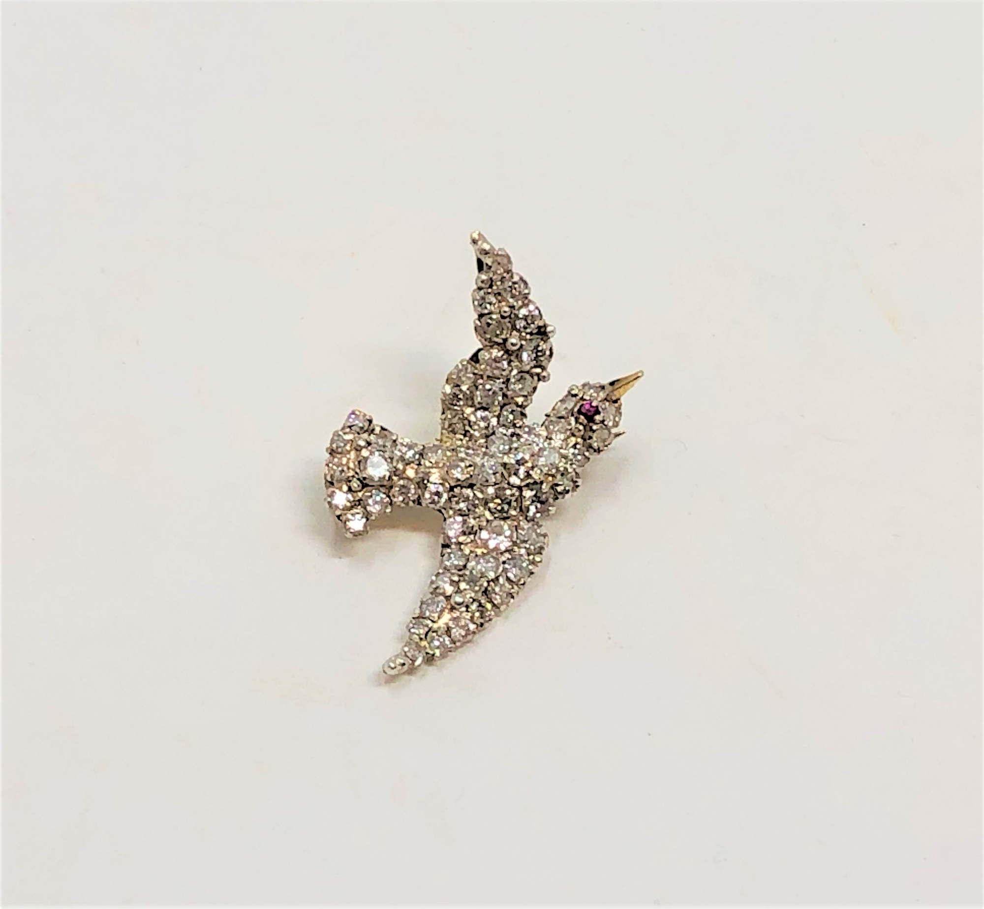 A superb quality antique diamond set swallow brooch with ruby eye,