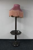 An early 20th century oak standard lamp fitted an octagonal wine table and pink tassel shade