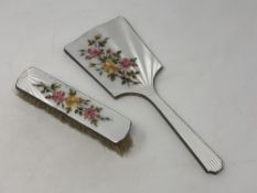 A two piece floral enamel and silver mirror and brush set
