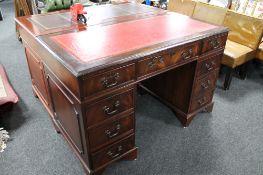 A mahogany twin pedestal writing desk with red tooled leather inset top
