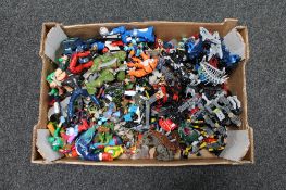 A box of assorted plastic action figures and Lego Bionicles