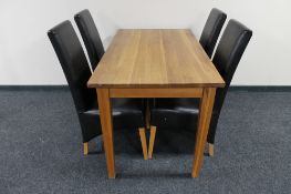 A contemporary oak dining table and four high back brown leather chairs