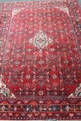 A woollen Persian rug on red ground