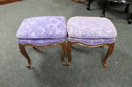 A pair of continental upholstered dressing table stools on cabriole legs