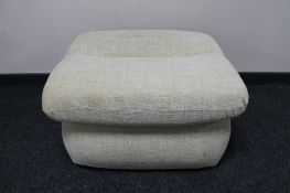 A contemporary footstool upholstered in a cream fabric